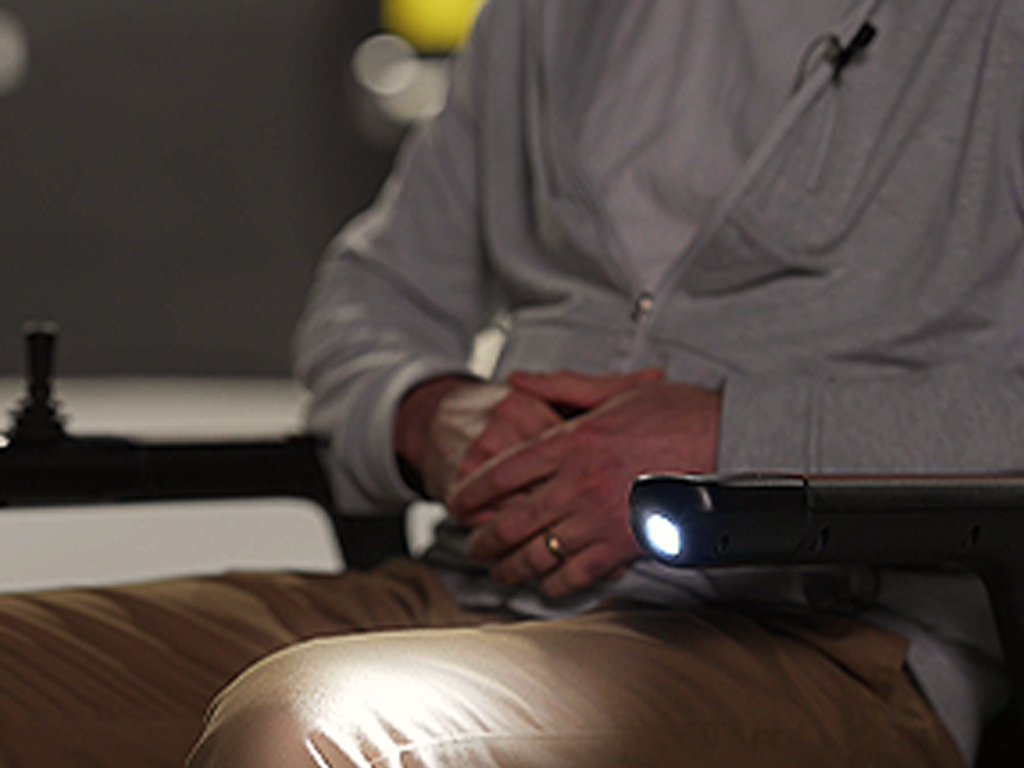 a man sitting on the robooter e40 electric wheelchair with the led light on